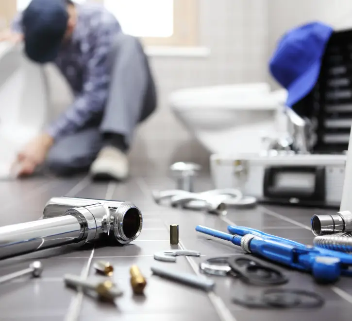 A plumber with parts and tools on the floor, mid fixture installation for a home in Central Illinois